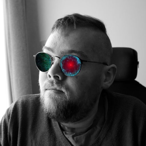 Black and white image of Ally, a bearded wheelchair user. The lenses of their glasses have been replaced with a colour image of a red and blue nebula.